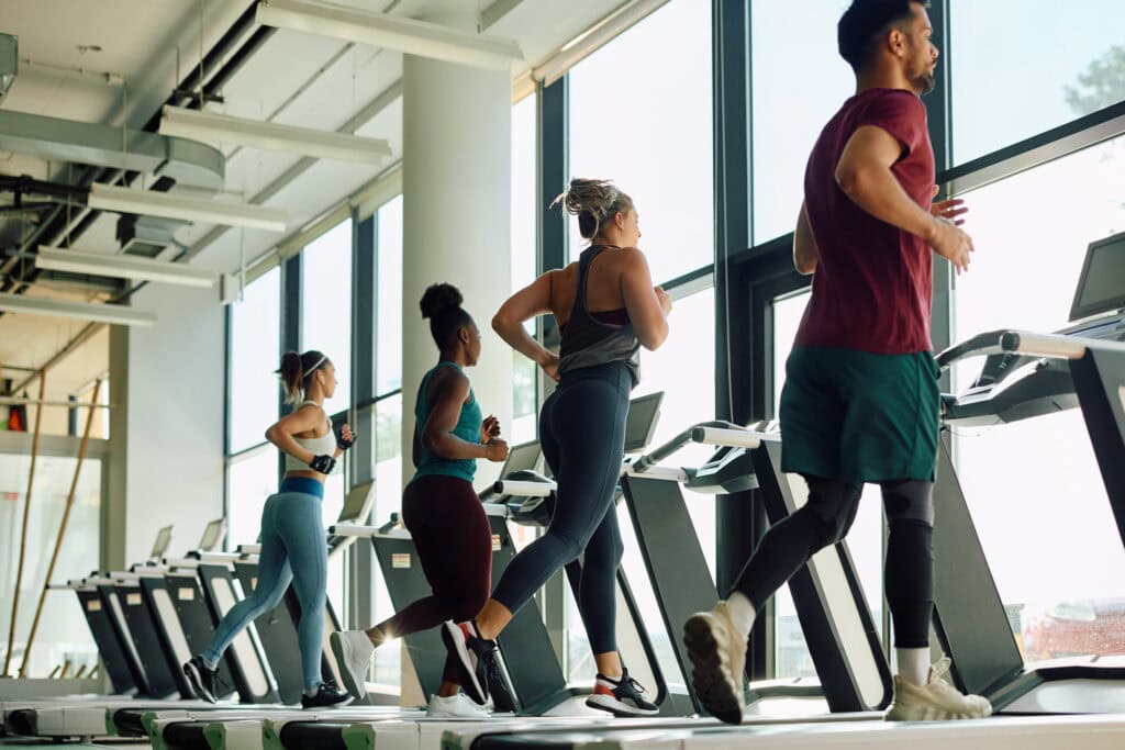 People running on treadmills in a nice community gym