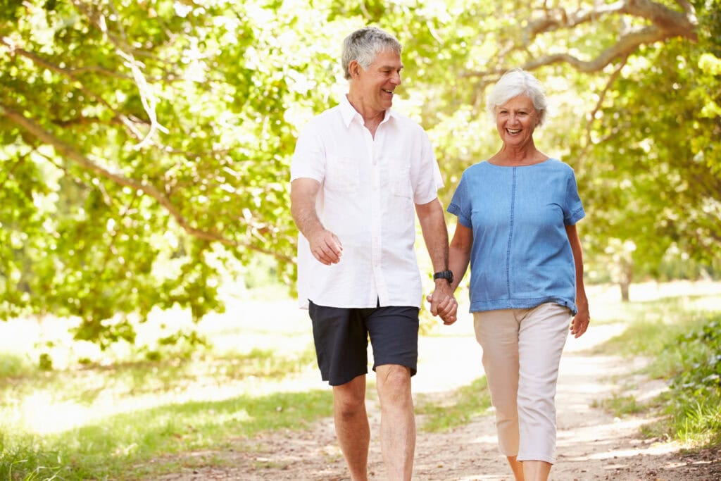 Couple enjoying a walk on a sunny day in a wooded park